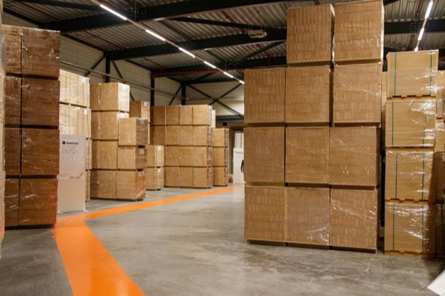 Warehouse interior with stacked cardboard pallets ready for shipment.